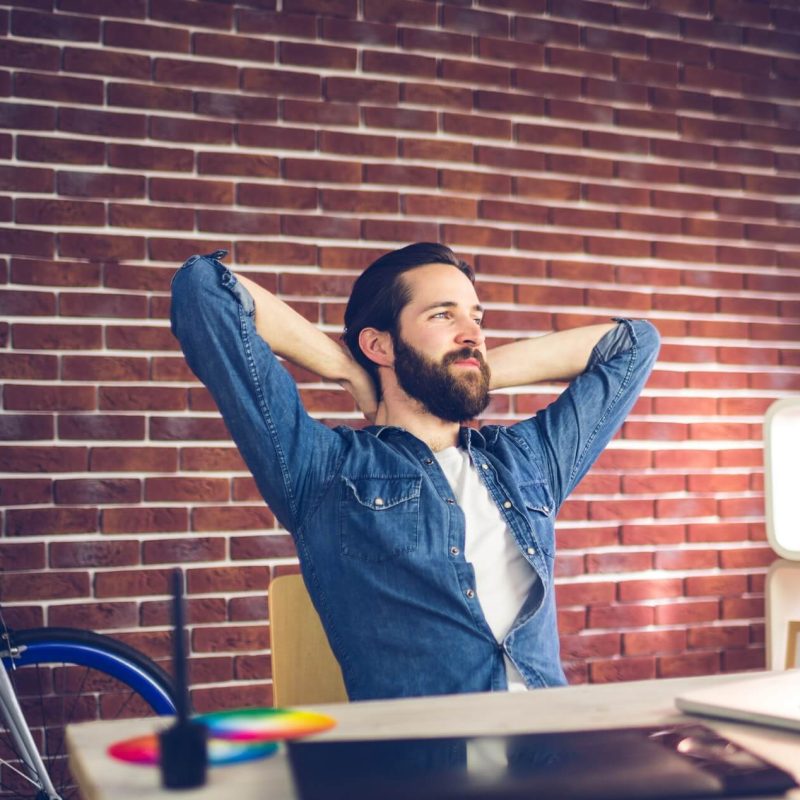 thoughtful-businessman-with-hands-behind-back-relaxing-in-creative-office-1.jpg